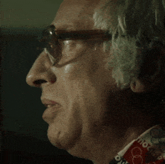 an older man wearing glasses and a shirt that says olympics