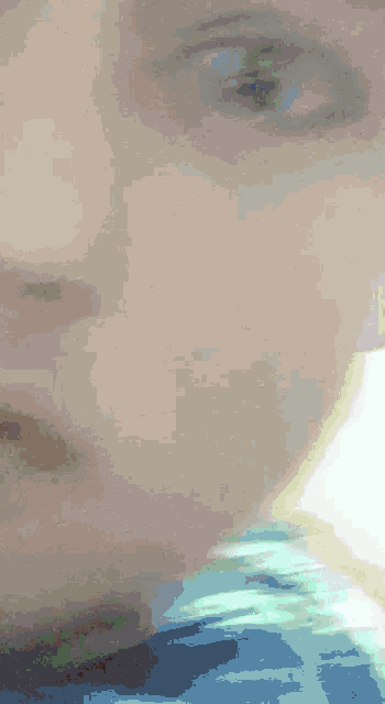 a close up of a person 's face with a blue shirt