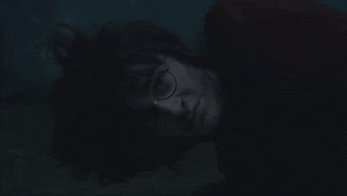 a close up of a person holding a pumpkin in front of their face in a dark room .