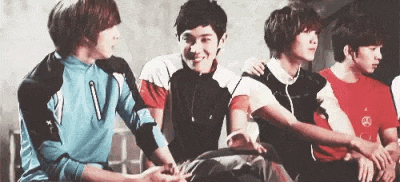a group of young men are sitting next to each other and hugging .
