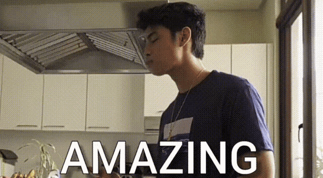 a young man is standing in a kitchen with the words amazing written on the bottom of the image .