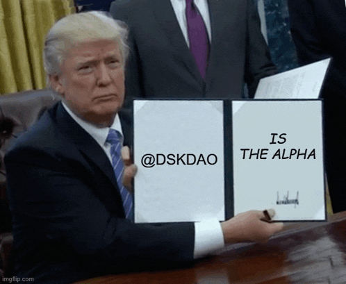 a man in a suit and tie is holding a piece of paper that says " is the alpha "