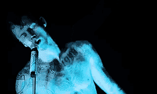 a man singing into a microphone with a tattoo on his chest that says ' 1991 '