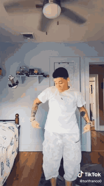 a woman is dancing in a bedroom with a tiktok watermark