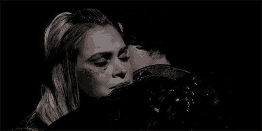a man and a woman are hugging in the dark .