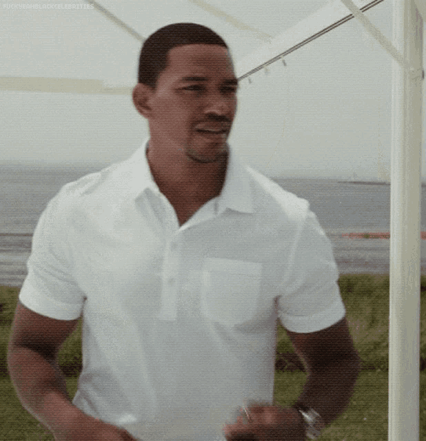 a man in a white shirt is standing in front of a white canopy