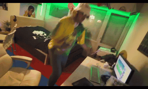 a person in a room with a computer and a bed
