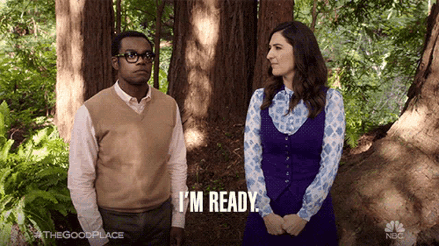 a man and a woman are standing in the woods and the man is saying i 'm ready