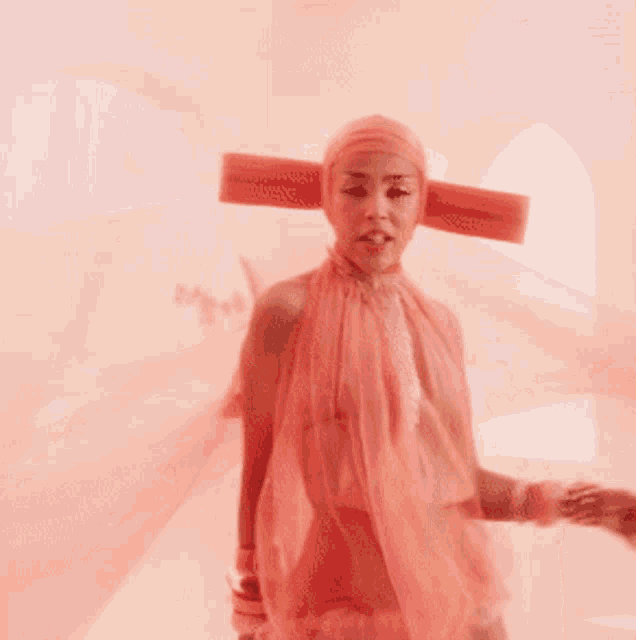 a woman wearing a pink dress and a pink hat is dancing