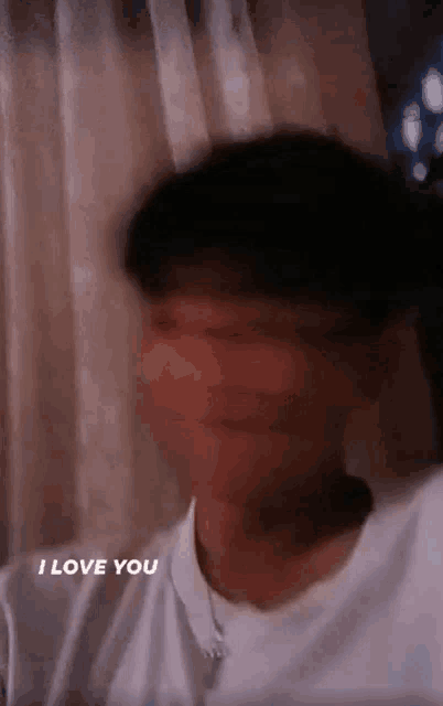 a blurry picture of a man 's face with the words `` i love you '' written below him .