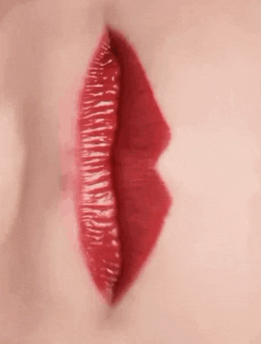 a close up of a woman 's red lips with red lipstick .