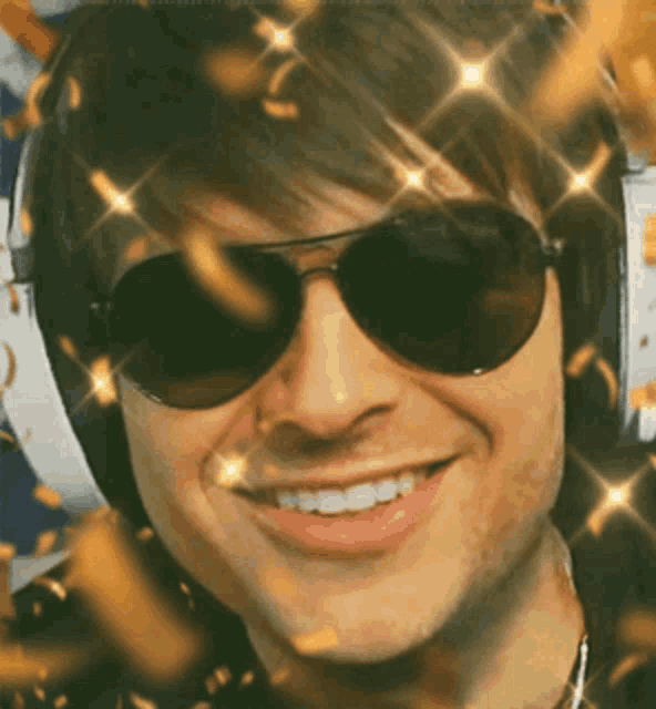 a man wearing sunglasses and headphones is smiling with gold confetti falling around him