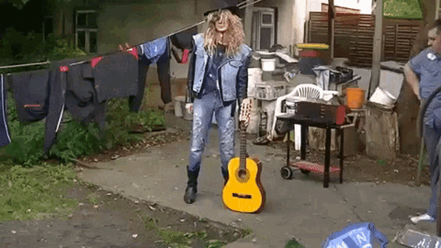 a man in a cowboy hat holding a guitar