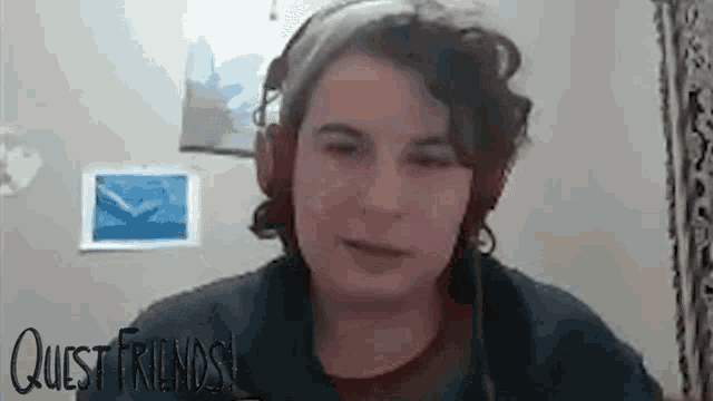 a woman is wearing headphones and looking at the camera .