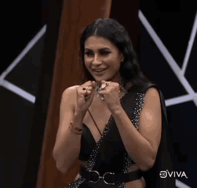 a woman in a black dress with rings on her hands