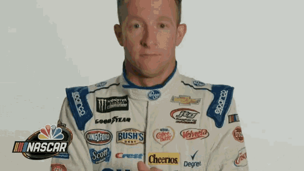 a man in a nascar uniform is giving the thumbs up