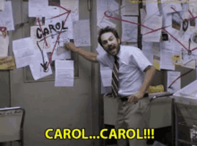 a man in a white shirt and tie is pointing at a board that says carol