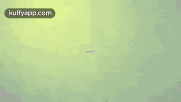 a white tube is flying in the air on a green background .