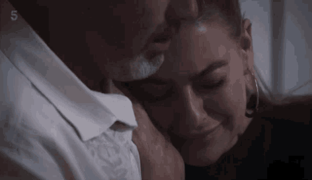 a man and woman are hugging with the number 5 on the bottom
