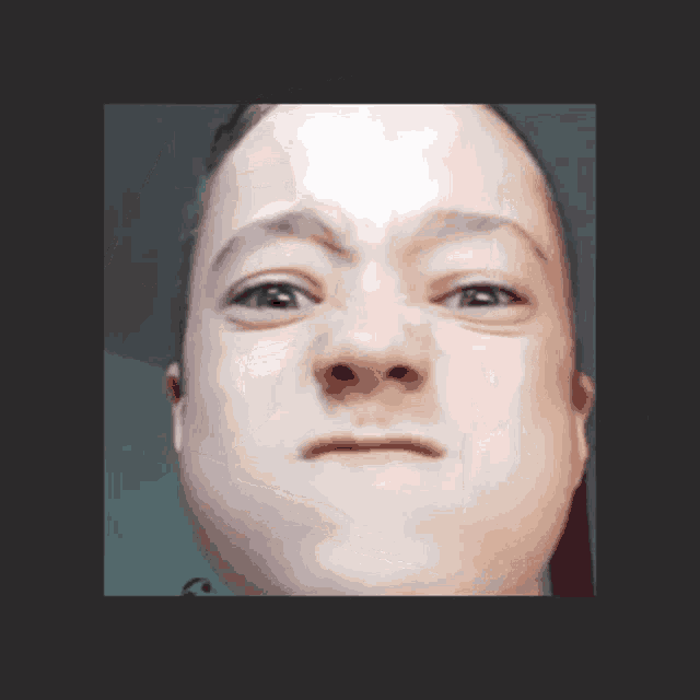 a close up of a person 's face with a serious expression