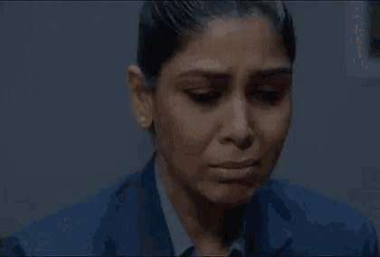 a close up of a woman crying with her eyes closed and her mouth open .