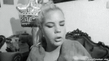 a black and white photo of a woman blowing out a birthday candle