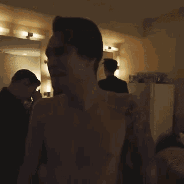 a shirtless man with a tattoo on his arm is screaming .