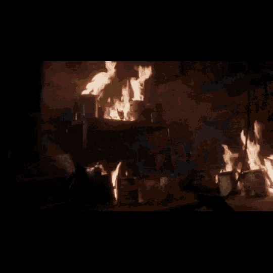 a close up of a person 's face surrounded by flames and smoke