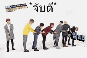 a group of men are standing in a row and one of them is holding another man 's butt in a line .