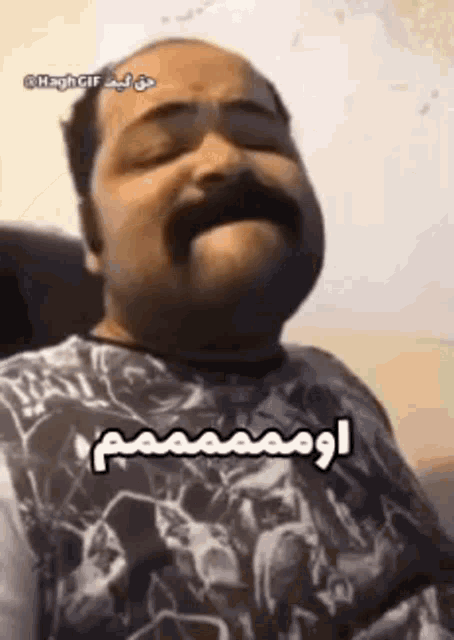 a man with a mustache is yawning with his eyes closed .