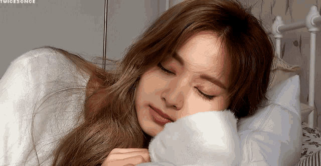 a woman laying on a bed with her eyes closed and the word twice on the bottom