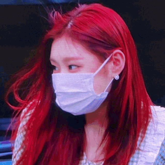 a woman with red hair is wearing a white mask