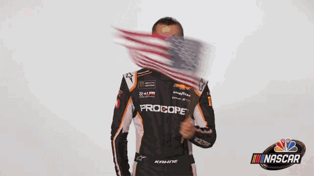 a man in a race car uniform is waving a flag and says happy 4th of july nascar