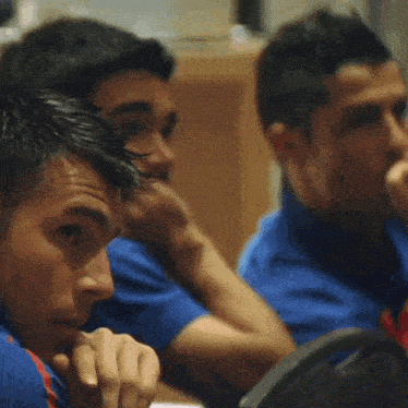 a man wearing a blue shirt with a red emblem that says ' soccer ' on it