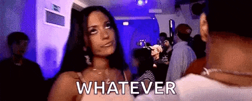 a woman is standing in a crowd of people at a party and says whatever .