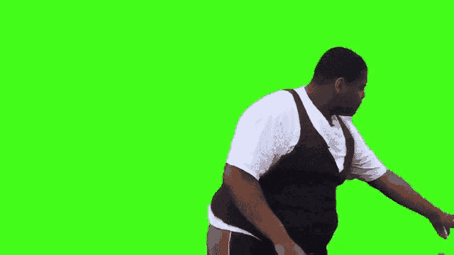 a man in a white shirt and black vest is standing in front of a green screen .