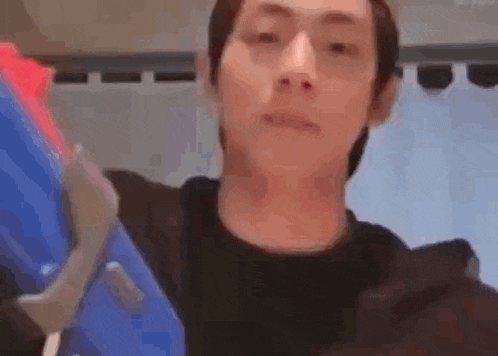a man is holding a blue toy gun in his hand .
