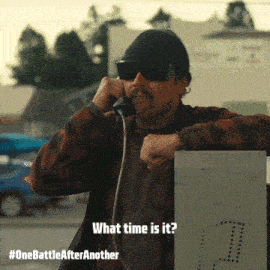 a man wearing sunglasses and a hat is talking on a phone with the words what time is it on the bottom