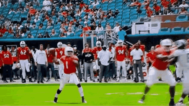 a football game is being played in a stadium with a crowd watching .