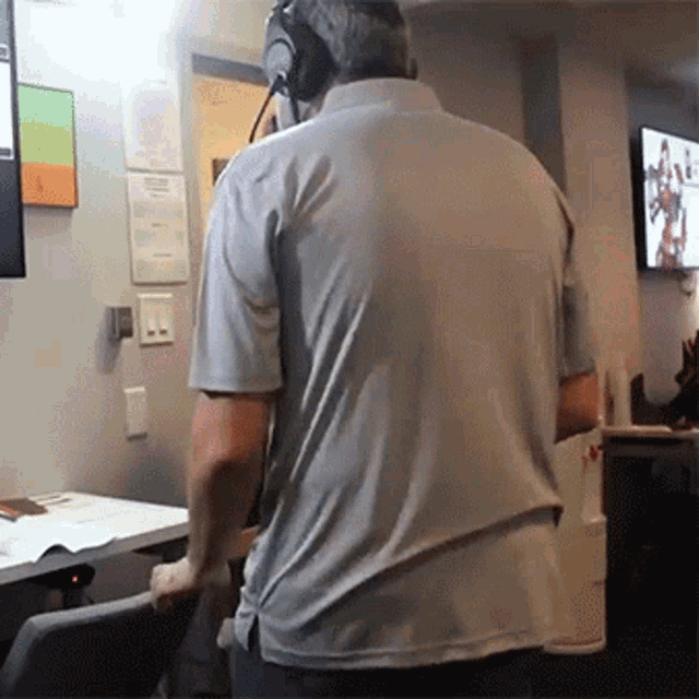 a man wearing headphones is standing in front of a monitor