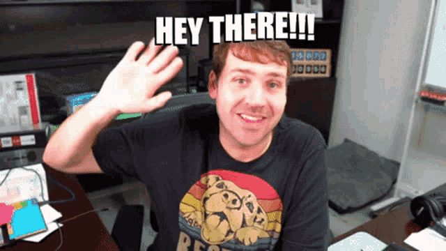 a man wearing a black shirt that says hey there on it