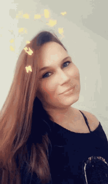 a woman with long red hair is smiling and wearing a black shirt
