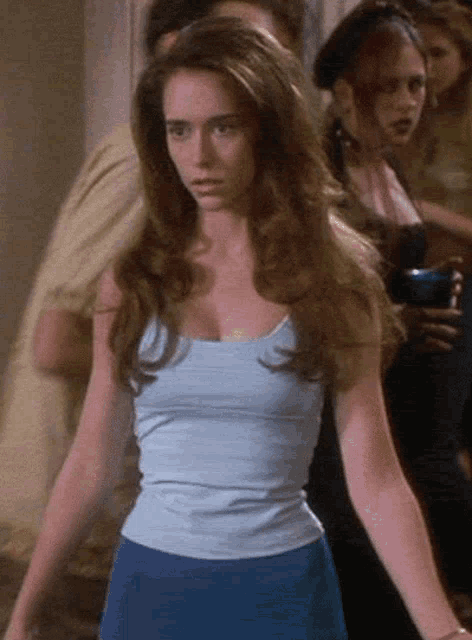 a woman in a light blue tank top and blue skirt