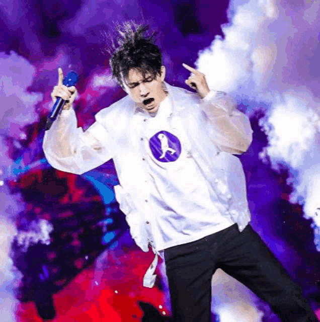 a man in a white jacket is singing into a microphone with smoke behind him