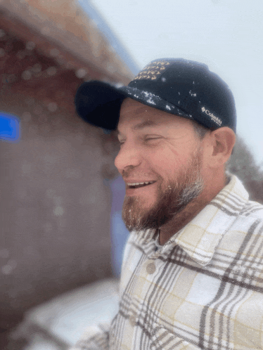 a man wearing a plaid shirt and a columbia hat