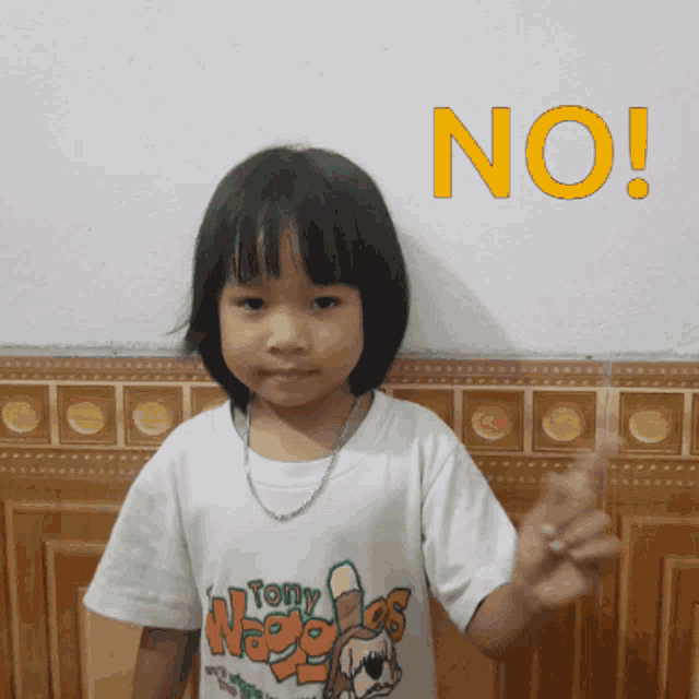 a little girl wearing a tony wages shirt stands in front of a no sign