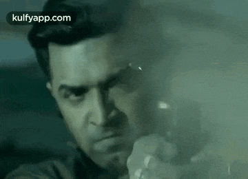 a man is holding a flashlight in his hand and pointing it at the camera .