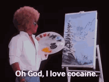 a man with an afro is holding a palette and painting a picture .