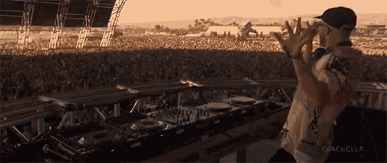 a man stands in front of a crowd with the words coachella on the bottom
