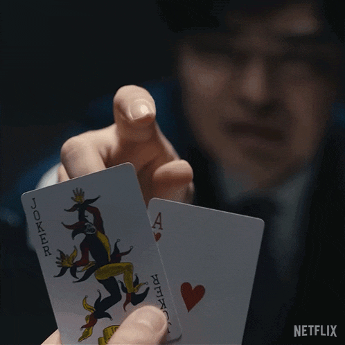 a man is holding two joker playing cards